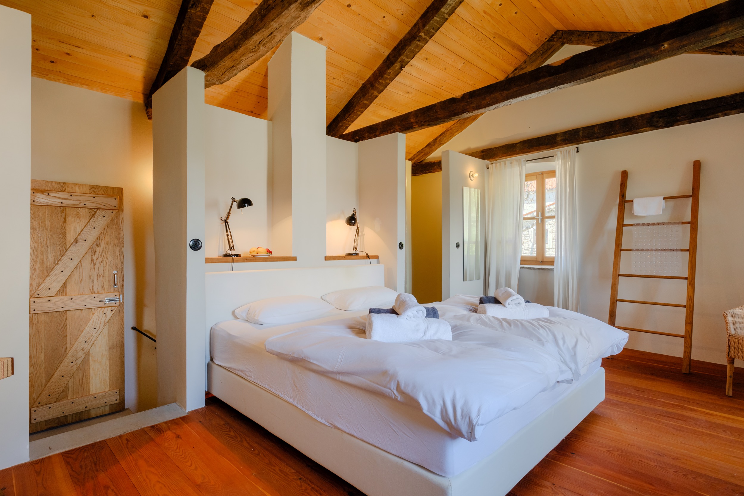 casa ceppi istria croatia interior bedroom rustic wooden door vaulted wood beam ceiling