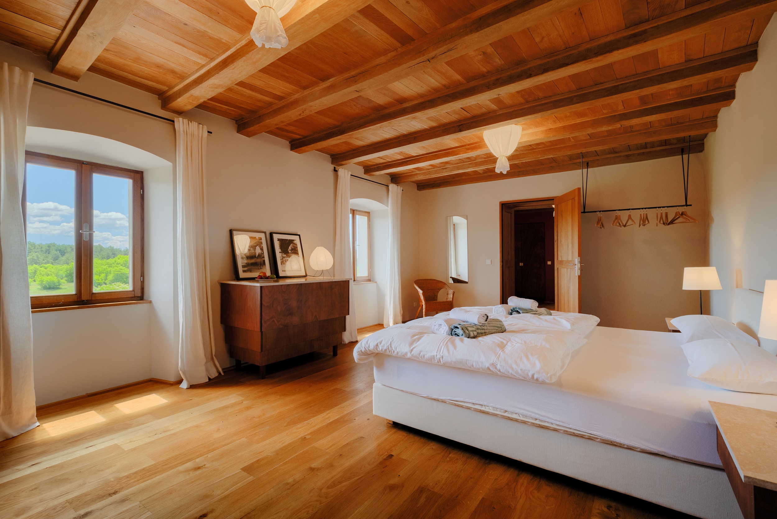 casa ceppi istria croatia interior bedroom wood beam ceiling dresser window countryside view
