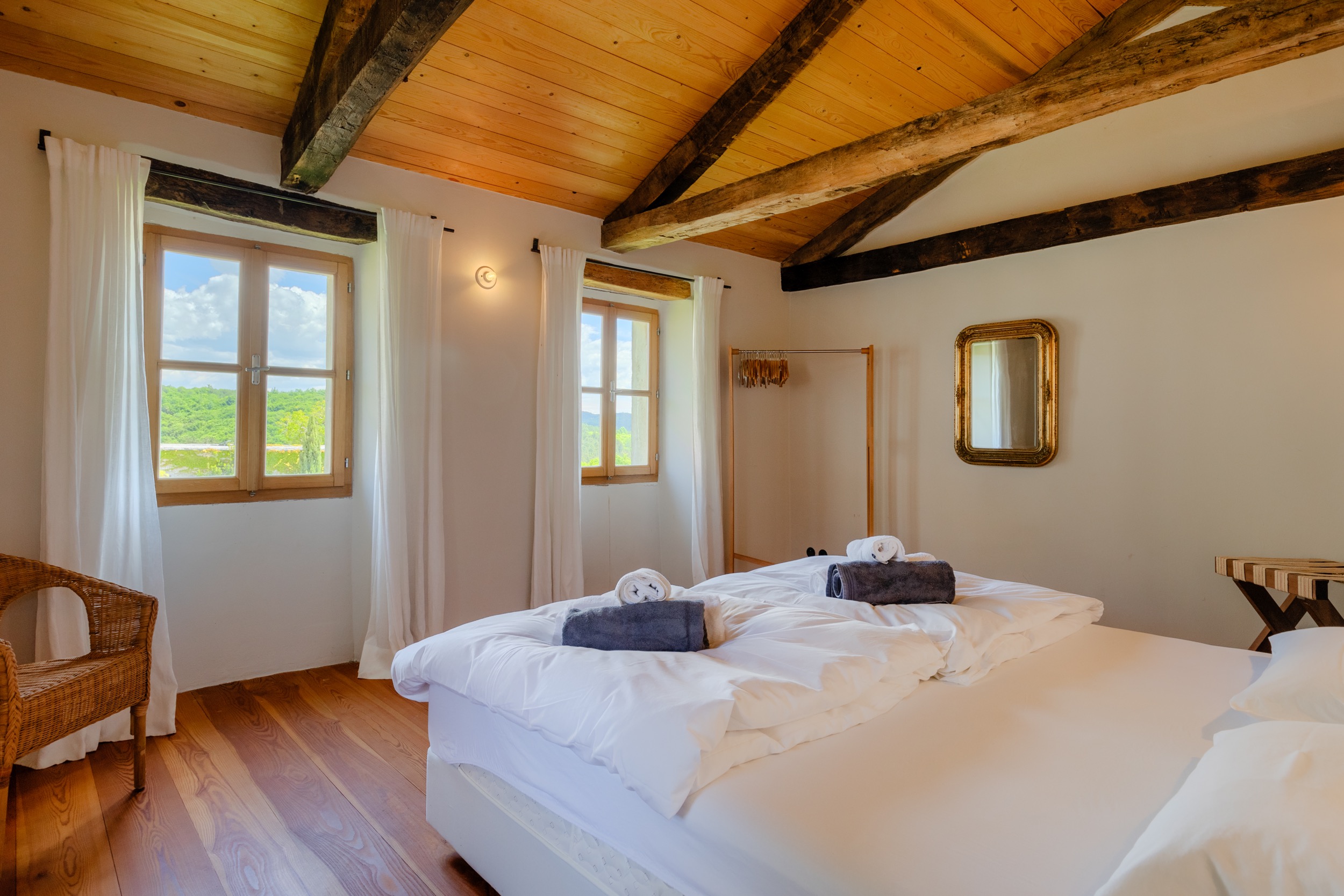 casa ceppi istria croatia interior bedroom wood beam ceiling gold mirror countryside view