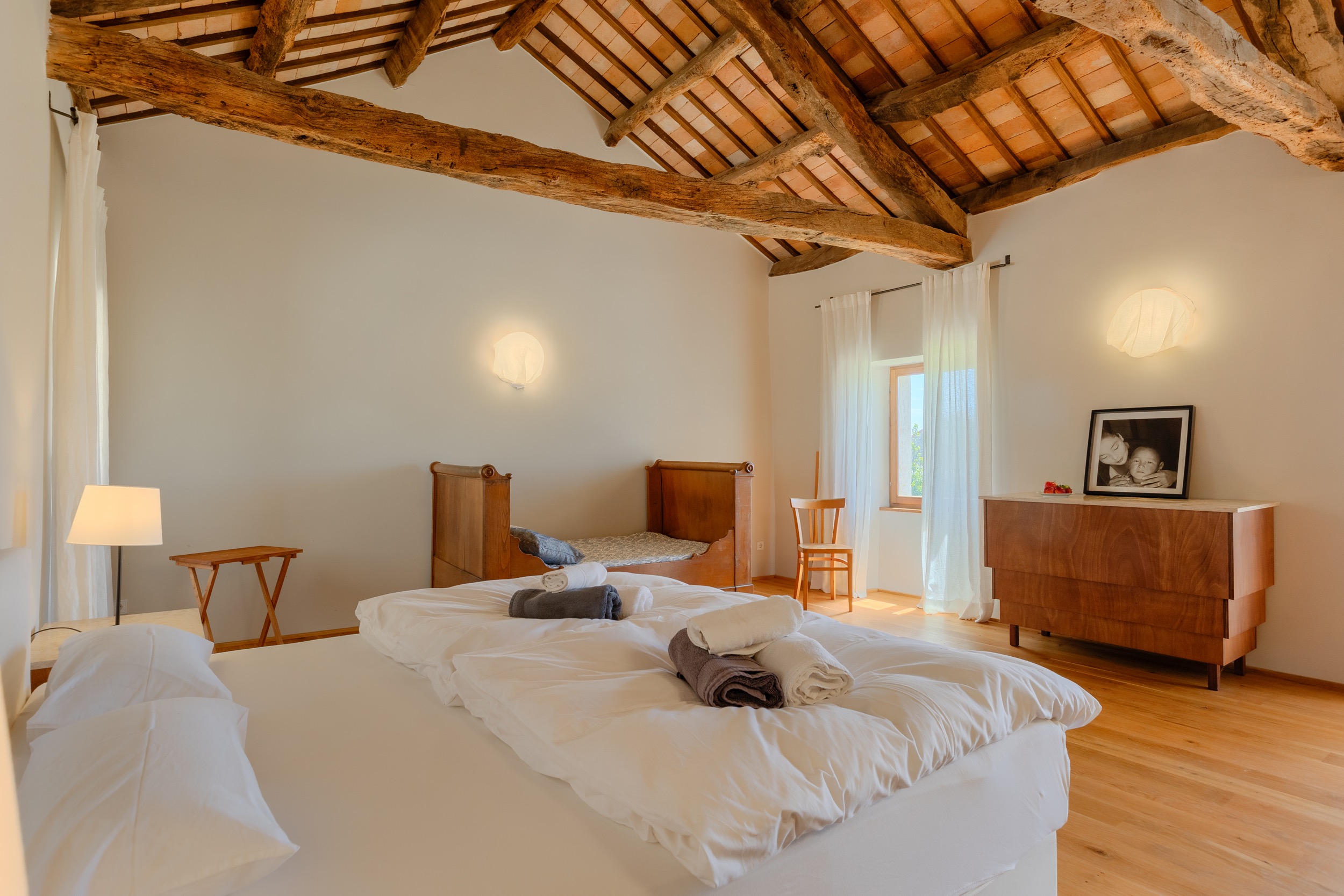 casa ceppi istria croatia interior bedroom wood beam ceiling wooden dresser artwork