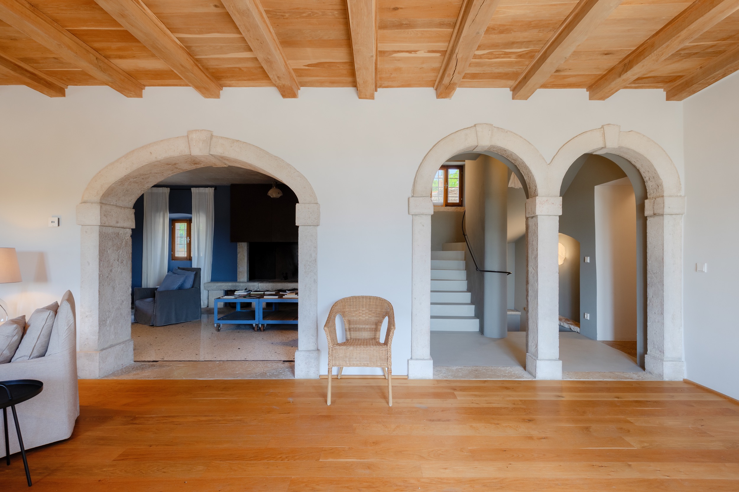 casa ceppi istria croatia interior hallway triple stone archways staircase wicker chair