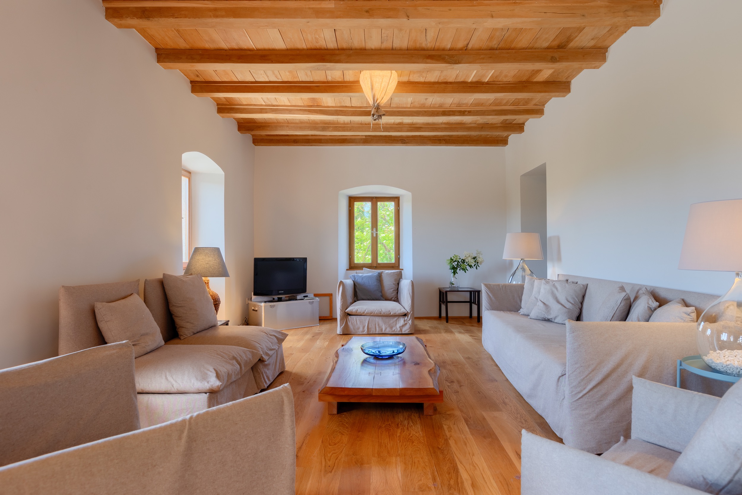 casa ceppi istria croatia interior living room beige sofas wooden beam ceiling arched window