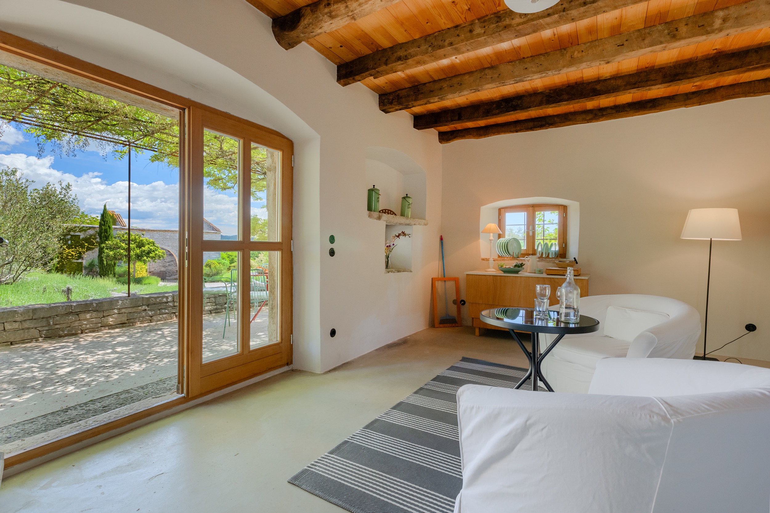 casa ceppi istria croatia interior sitting room wood beam ceiling french doors garden view