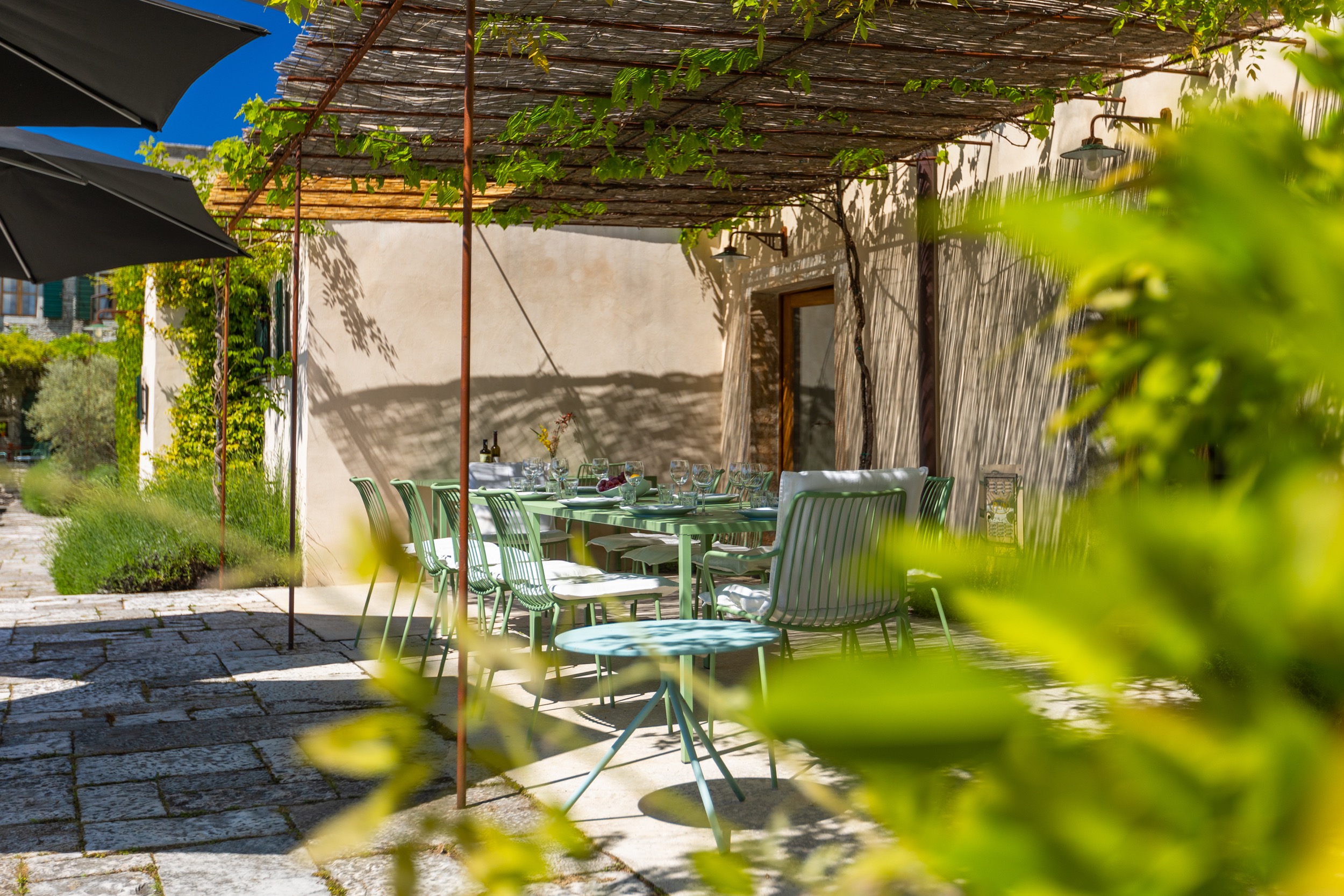 casa ceppi istria croatia pergola terrace green outdoor chairs stone wall close up