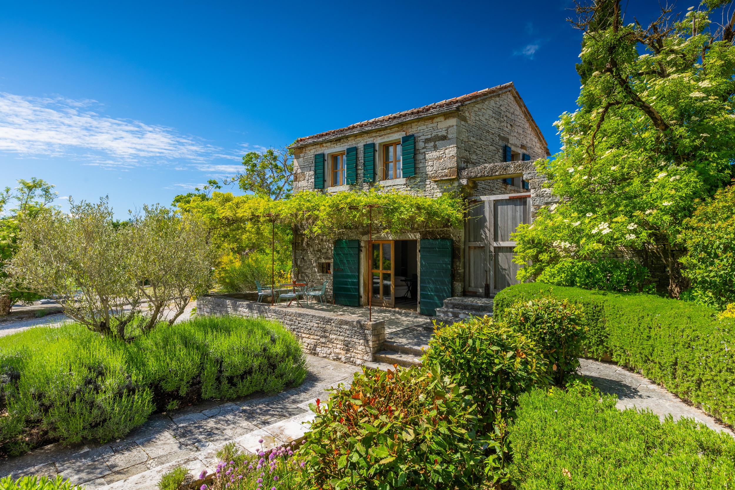 casa ceppi istria croatia stone house facade close up boxwood hedges gravel path