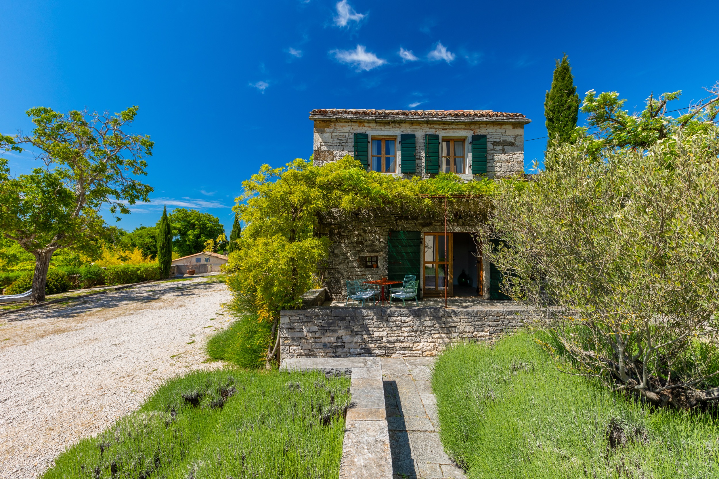 casa ceppi istria croatia stone house facade green shutters wisteria gravel path lavender